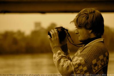 photographie “Le Jour ni l’Heure 5273 : portrait d’un photographe sous un pont (Jean-Michel Leroy), bords de la Seine, Champrosay, Draveil, Essonne, lundi 12 novembre 2012, 16:46:37” par Renaud Camus — www.renaud-camus.net — Seine, bridge, photographer, man, homme, jeune homme, young man, camera