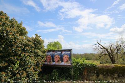 photographie “Le Jour ni l’Heure 4628 : En Lomagne — la campagne électorale à Plieux, Gers, Gascogne, mardi 9 avril 2024, 16:51:43” par Renaud Camus — www.renaud-camus.net — affiches, campagne électorale, européennes, élections européennes, affiche, Marion, Marion Maréchal, Marion Maréchal Le Pen, Plieux, Gers, Gascogne, Lomagne, En Lomagne, place Saint-Jean, chartreuse